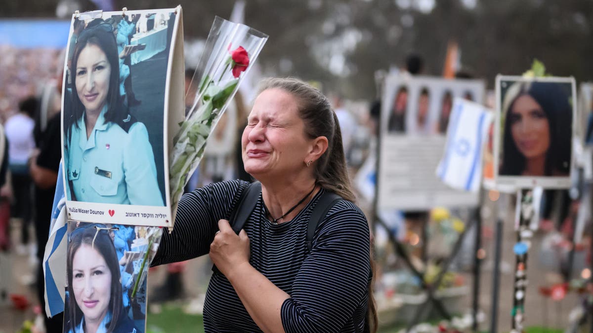 RE'IM, ISRAEL - OCTOBER 07: A woman breaks down at the memorial to Yulia Waxer Daunov as family members and friends of the lost and kidnapped gather at the site of the Nova Festival to mark the one year anniversary of the attacks by Hamas, on October 07, 2024 in Re'im, Israel. Various commemorations are taking place around Israel to mark the  anniversary of the Hamas attacks in Israel. On October 7, 2023, members of Hamas mounted a series of attacks and raids on Israeli citizens in the Gaza Envelope border area of Israel. 251 Israelis and foreigners were kidnapped with nearly 100 still unaccounted for and 1139 people were killed. (Photo by Leon Neal/Getty Images)