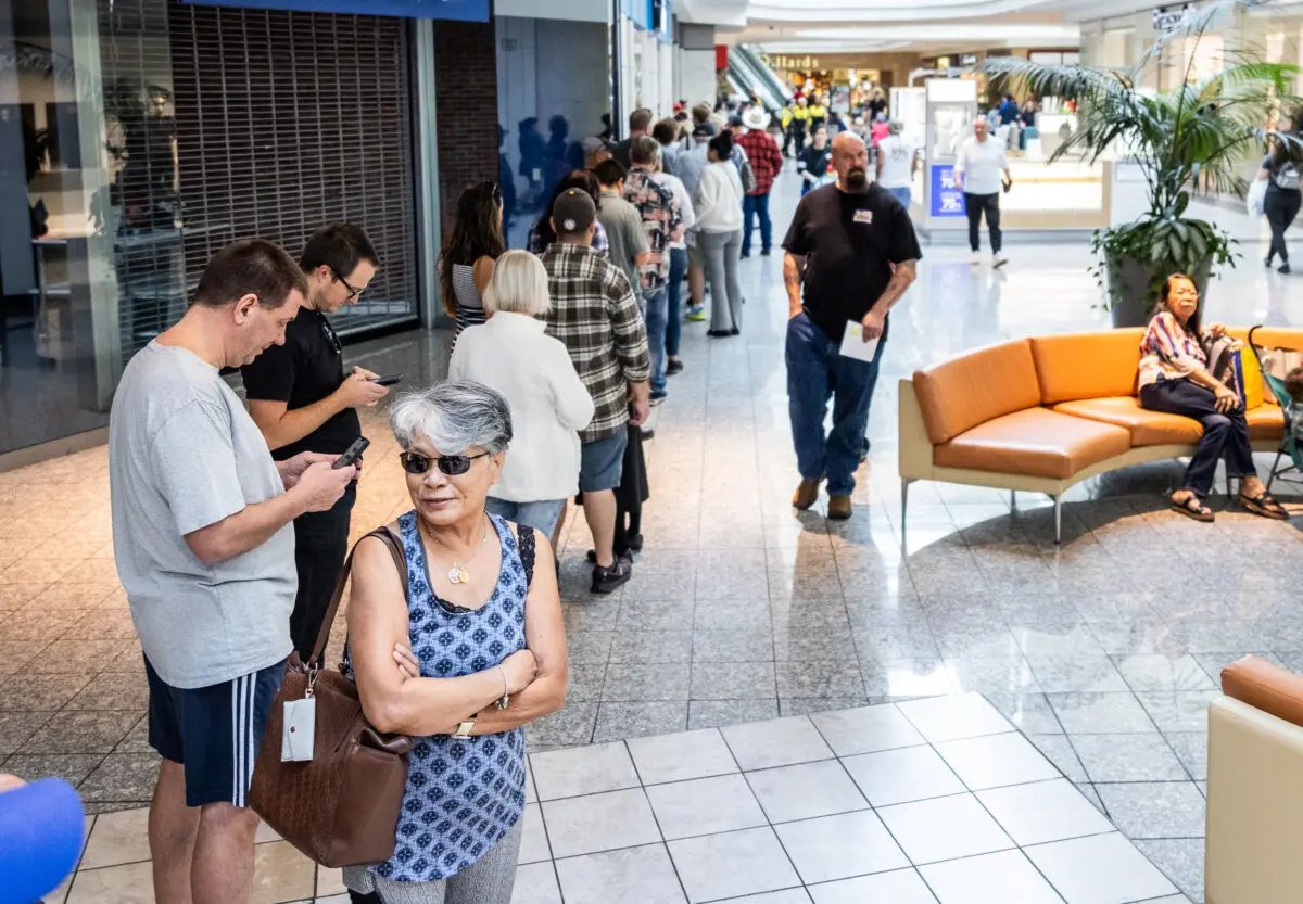 People wait in long lines to cast their votes at a shopping mall in Henderson, Nev., on Oct. 19, 2024. (John Fredricks/The Epoch Times)