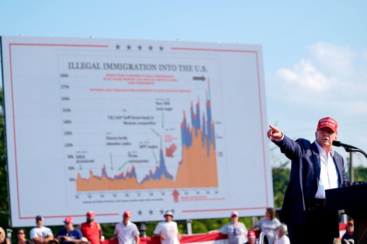 Former President Donald Trump points to an immigration data chart on display moments before he was shot. (Evan Vucci/AP Photo)