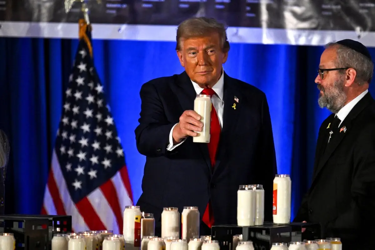 Former U.S. President and Republican presidential candidate Donald Trump holds a candle at a remembrance event to mark the first anniversary of the Hamas attack on Israel at Trump National Doral golf club in Miami, Fla., on Oct. 7, 2024. (Chandan Khanna/AFP)