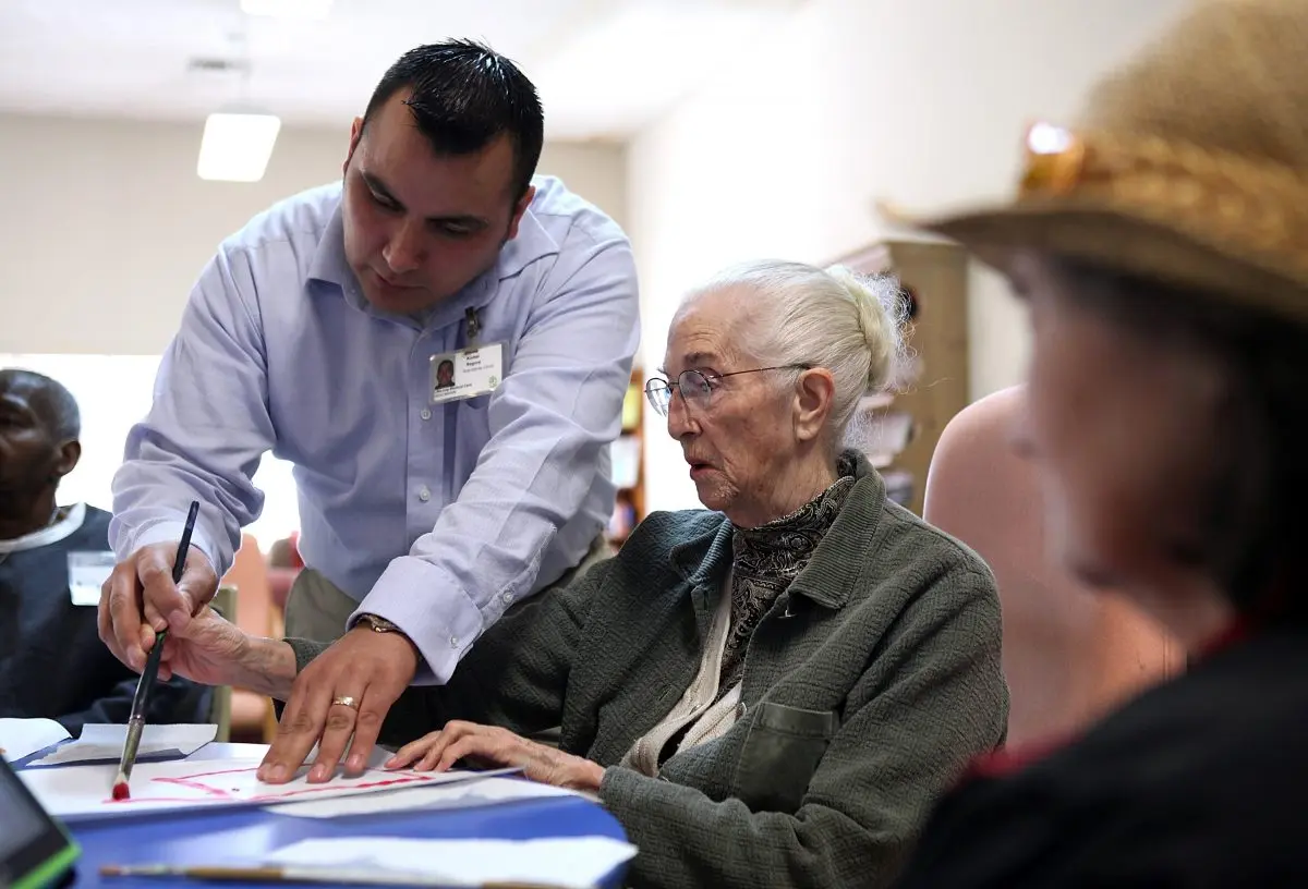 A worker assists an elderly woman during an activity session in a Day Care center in California on Feb. 10, 2011. (Justin Sullivan/Getty Images)