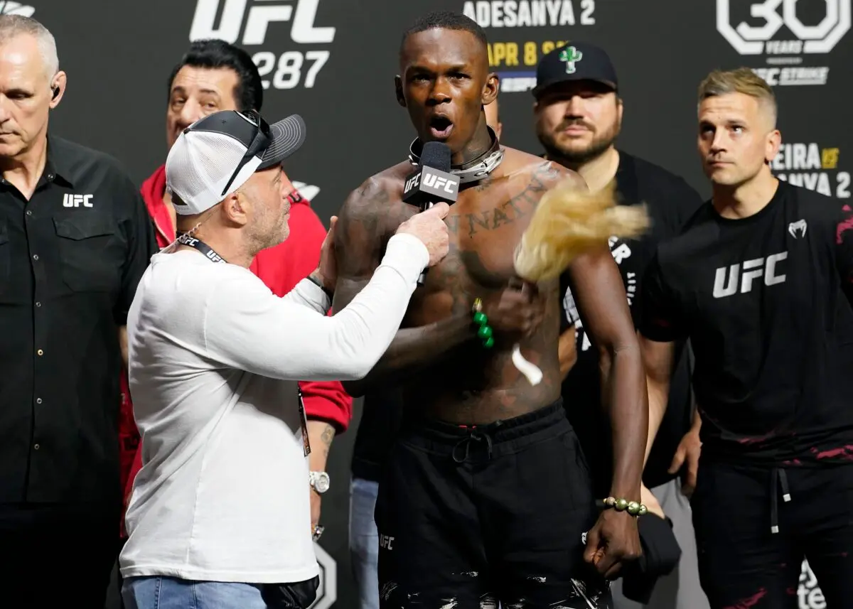 UFC commentator Joe Rogan, front left, listens to Israel Adesanya after a ceremonial weigh-in, in Miami, on April 7, 2023. (Marta Lavandier/AP Photo)