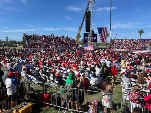 A crowd starts to form around the bulletproof glass podium where Trump later spoke at a rally in Coachella, Calif., on Oct. 12, 2024. (Brad Jones/The Epoch Times)