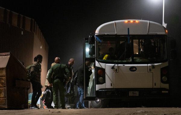 Migrants prepare to be transported by bus to processing facilities in Yuma, Arizona, on May 18, 2023. (John Fredricks/The Epoch Times