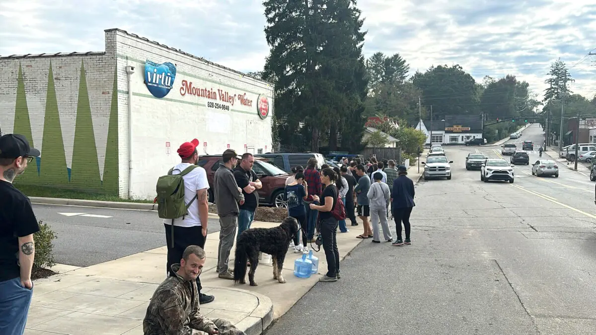 People wait to gather water at Mountain Valley Water in the aftermath of Hurricane Helene in West Asheville, N.C., on Sept. 30, 2024. (Jeffrey Collins/AP Photo)