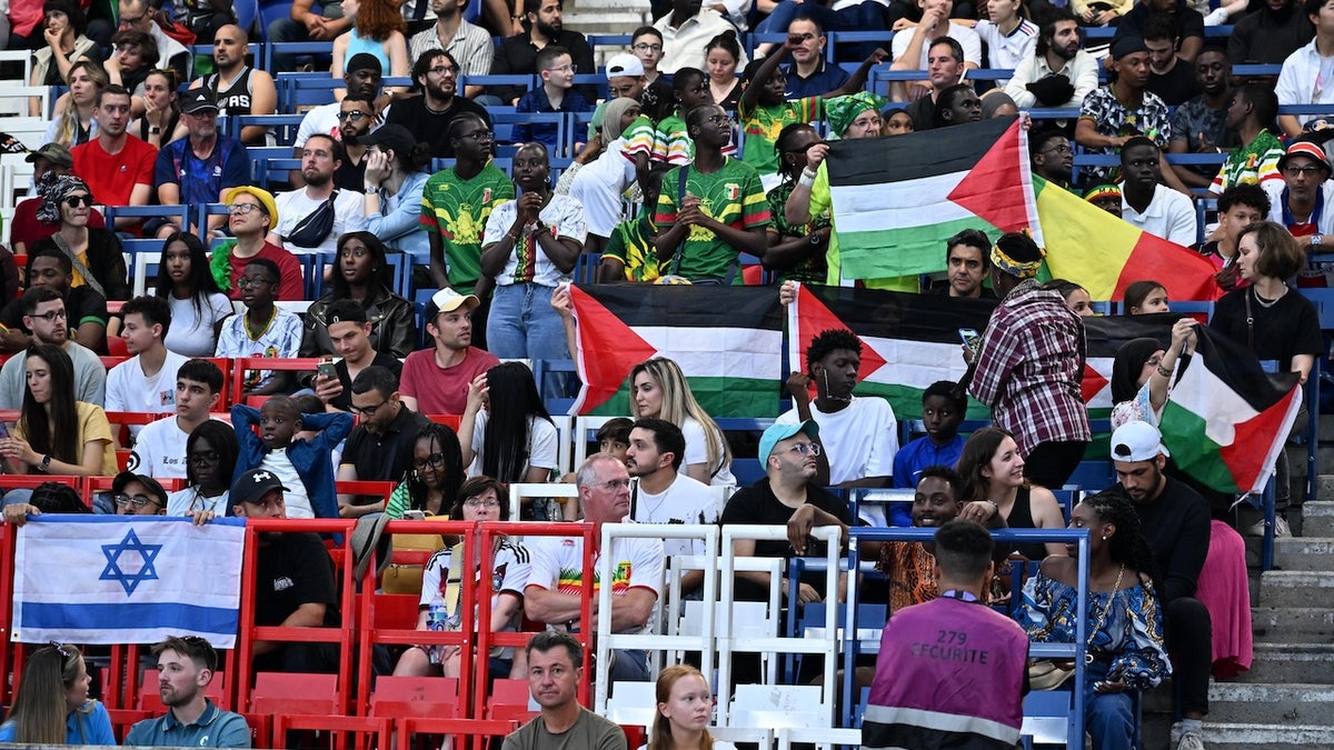 Fans open Palestinian flags during the Men's group D match between Mali and Israel during the Paris 2024 Olympic Games at Parc des Princes stadium.