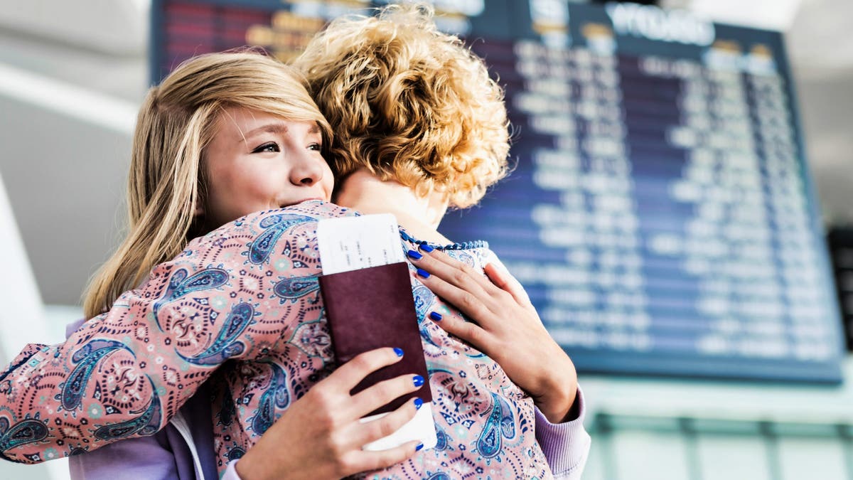 people hugging airport