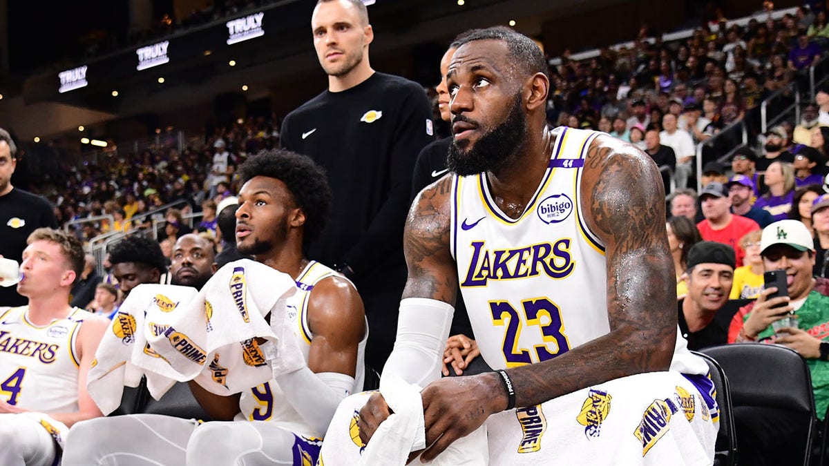 LeBron and Bronny James sit on bench