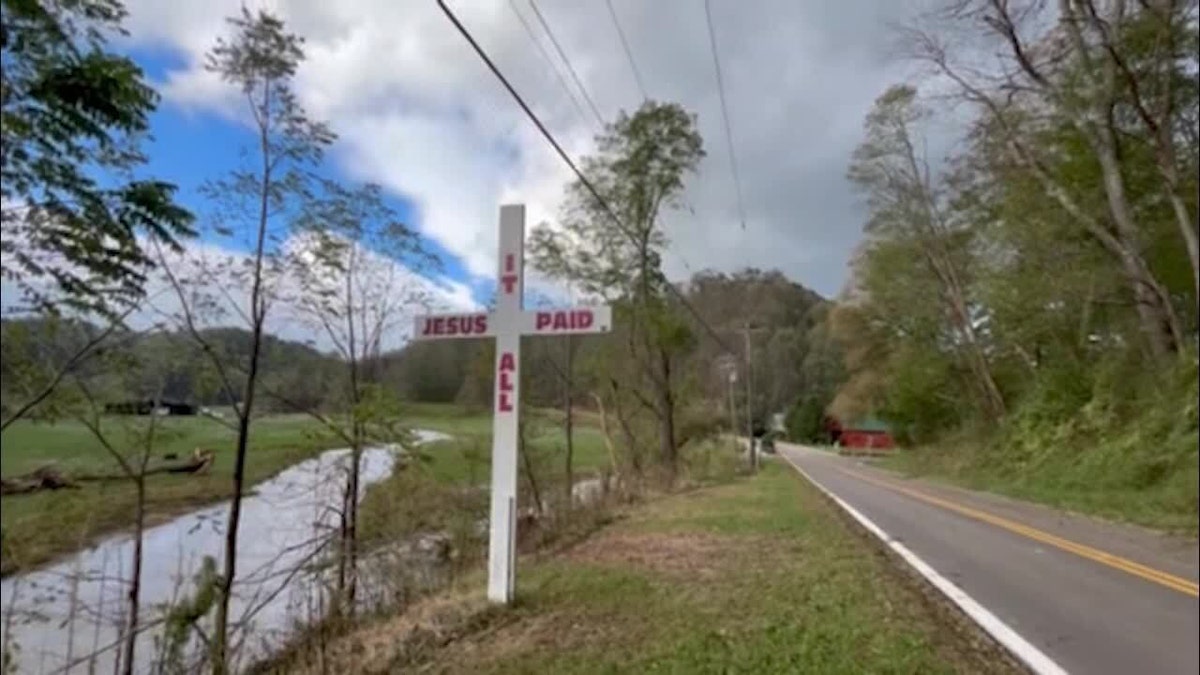 Cross on side of road reading 