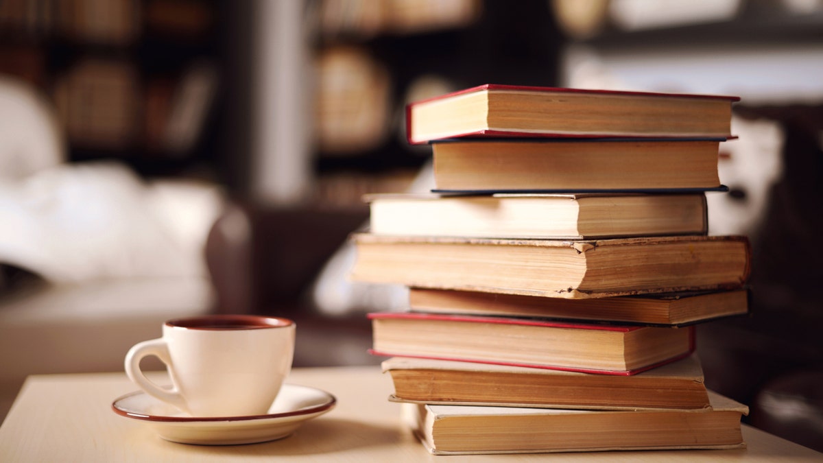 Stacks of books on a table with coffee