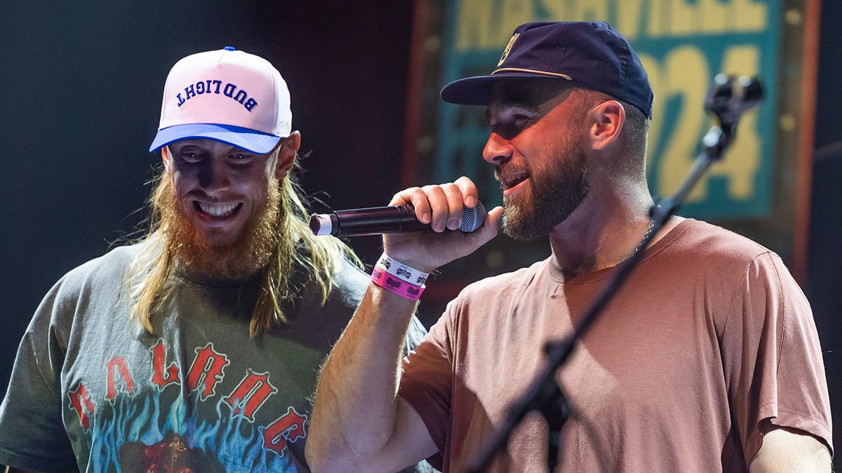 George Kittle and Travis Kelce greet an audience 