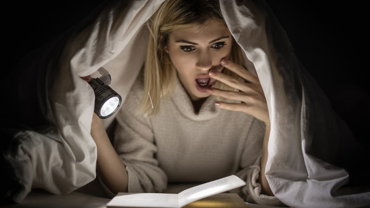 A woman reading a scary book