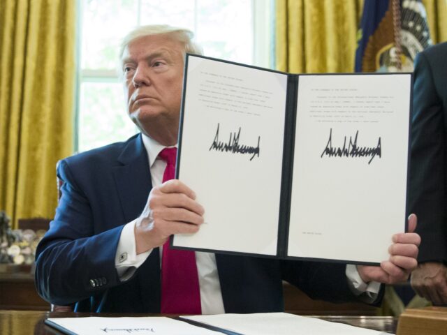 FILE - In this Monday, June 24, 2019 file photo, President Donald Trump holds up a signed