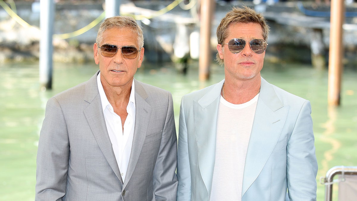 George Clooney and Brad Pitt posing together in sunglasses