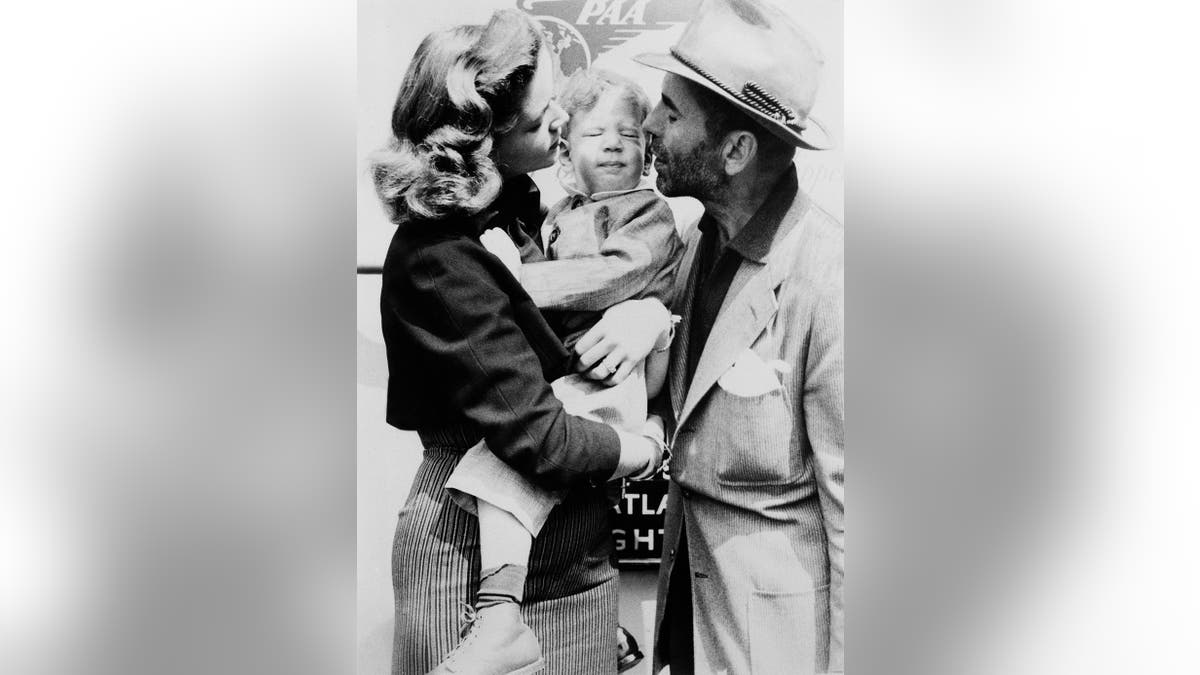 Lauren Bacall and Humphrey Bogart kissing Stephen Bogart.