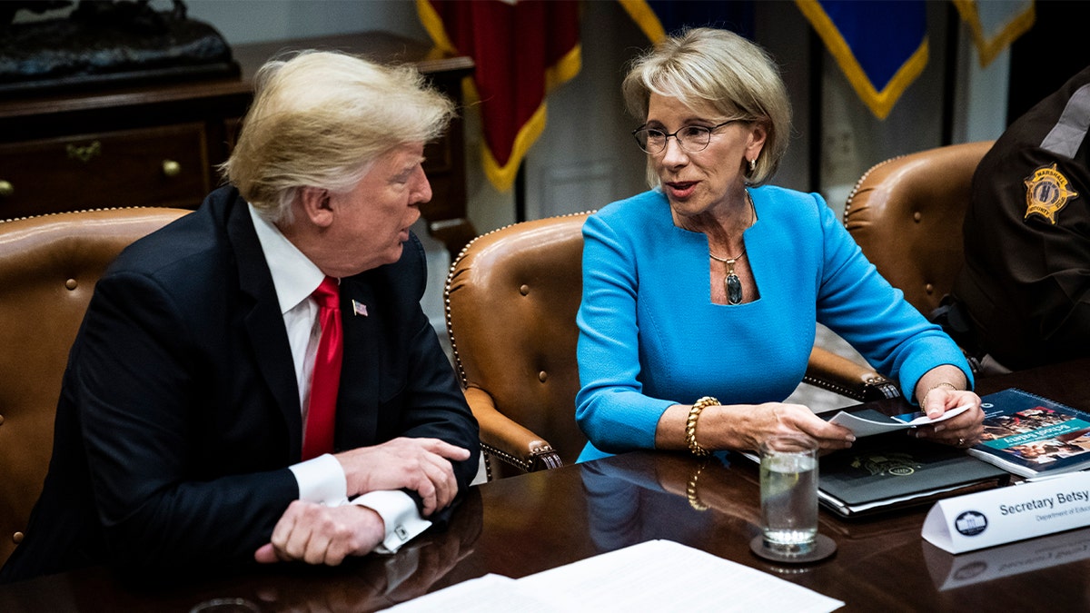 Then-President Trump speaks with then-Secretary of Education Betsy DeVos at a roundtable with family members of victims, state and local officials, and Cabinet members to discuss recommendations in the Federal Commission on School Safety Report in the Roosevelt Room at the White House on Tuesday, Dec. 18, 2018 in Washington, D.C.