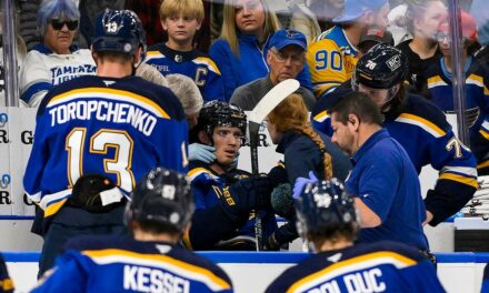 Blues player hit in neck with puck, keeps playing before eventually being stretchered off