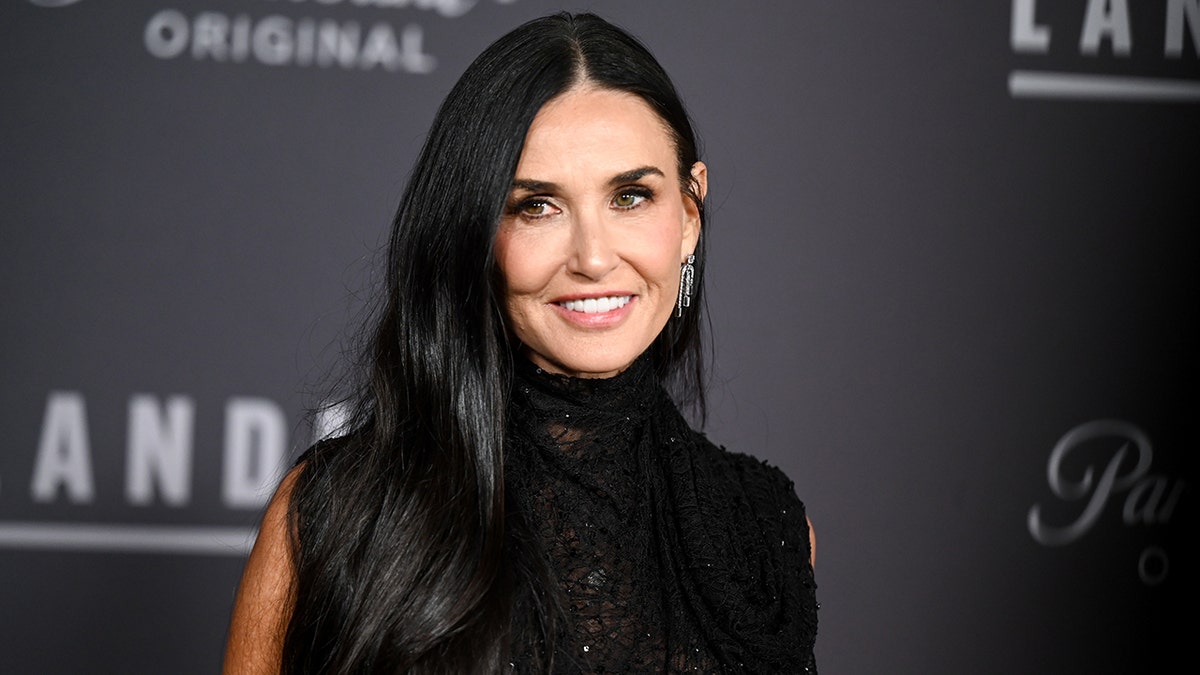 Demi Moore in a black sleeveless turtleneck looks slighly to her right on the carpet