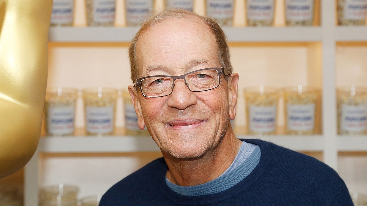 A close-up of Stephen Bogart in a blue sweater smiling.