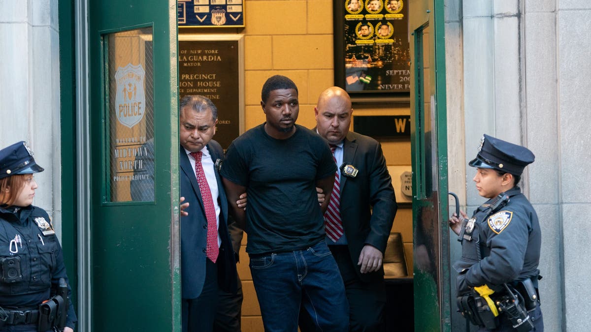 Jaheem Warren being led out of an NYPD building. 