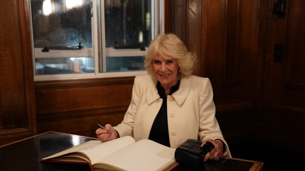 Camilla signing a guest book