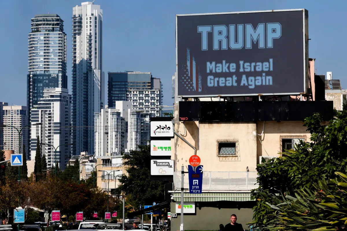 A man walks in front of a billboard displaying a message in support of U.S. presidential candidate Donald Trump in Israel's coastal city of Tel Aviv on Nov. 5, 2024. (Jack Guez/AFP via Getty Images)