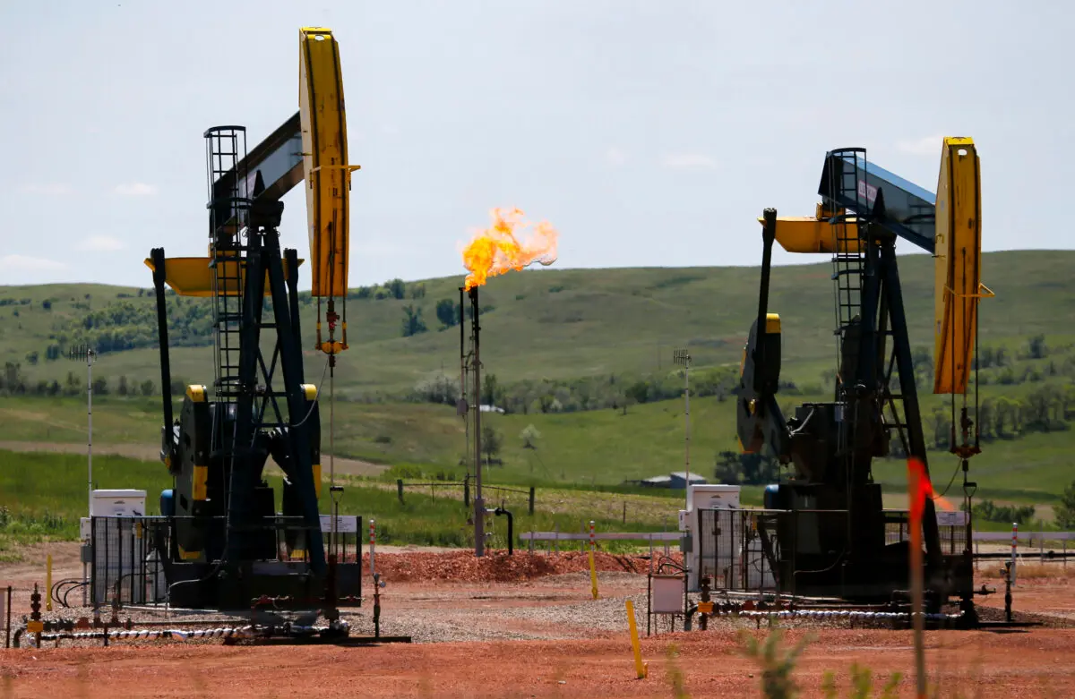 Oil is pumped and natural gas is flared off at an oilfield near Watford City, N.D., on June 12, 2014. (Charles Rex Arbogast/AP Photo)