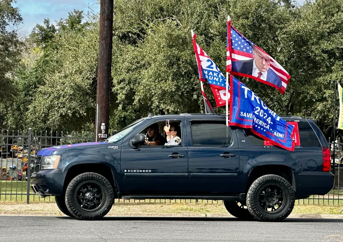 A Trump supporter uses her phone to video the long line of cars behind her that participated in a Trump rally in McAllen, Texas, on Nov. 9, 2024. (Darlene McCormick Sanchez/The Epoch Times)