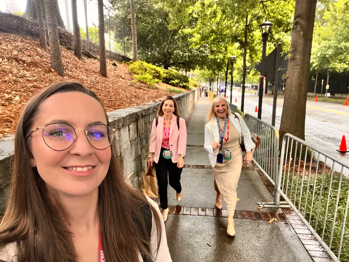 Epoch Times photographer Madalina Vasiliu (L) snaps a selfie as Epoch Times reporters Emel Akan (C), and Janice Hisle (R) make their way toward the venue for the presidential debate between President Joe Biden and former President Donald Trump in Atlanta, Ga., on June 27, 2024 (Madalina Vasiliu/The Epoch Times)