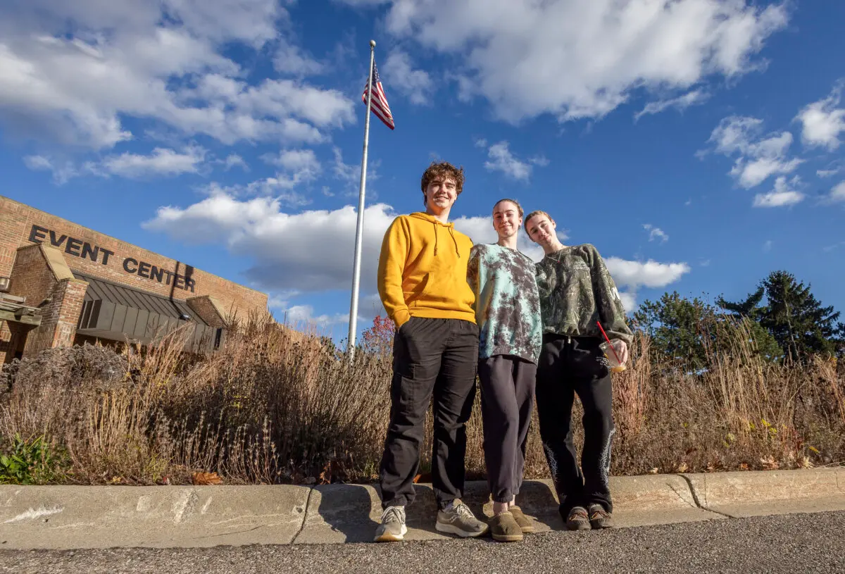 Nathan Rehm (L) stands with friends near an early voting site in Waterford Oaks, Mich., on Oct. 26, 2024. (John Fredricks/The Epoch Times)