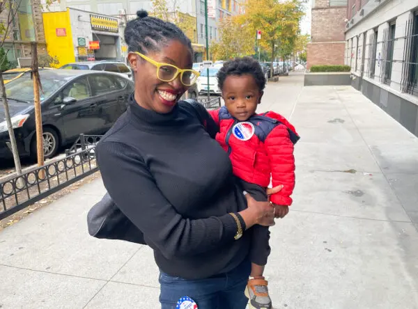 Kariyam Reid of New York City, with her son Champion, says she voted for Harris, on Nov. 5, 2024. (Richard Moore / The Epoch Times)