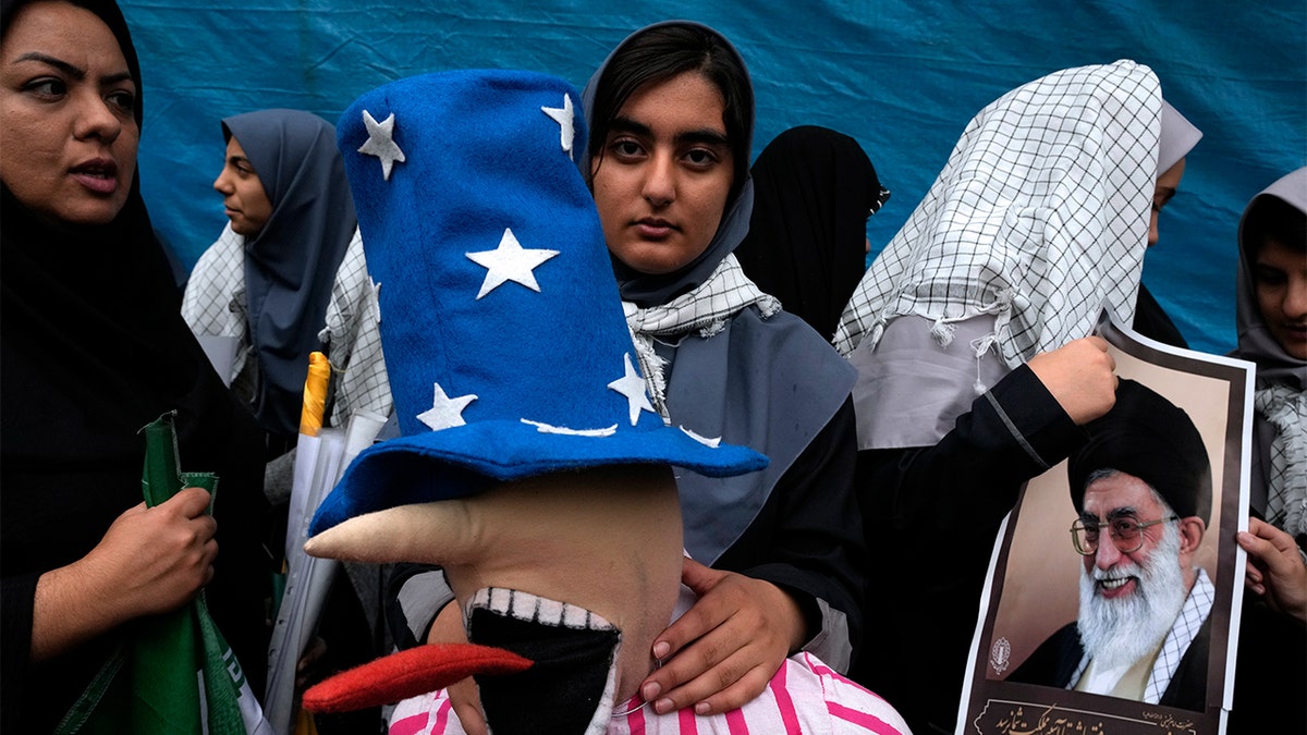 Iranian schoolgirl holds effigy of Uncle Sam