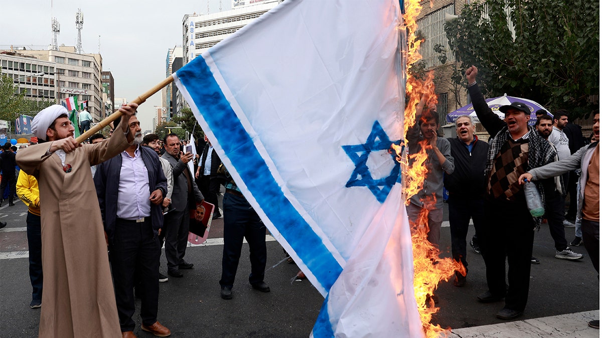 Iranian protesters burn Israeli flag