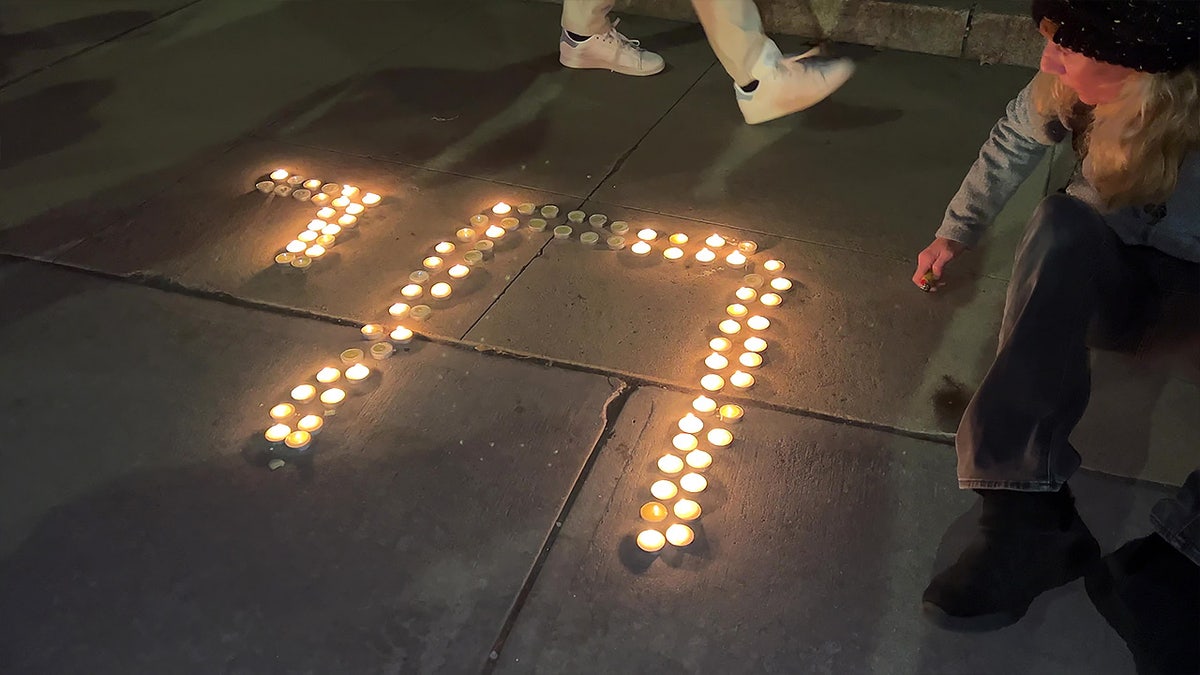 Woman lights candles on ground