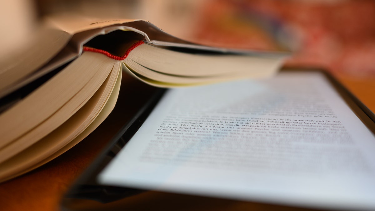 Kindle and a book on a table