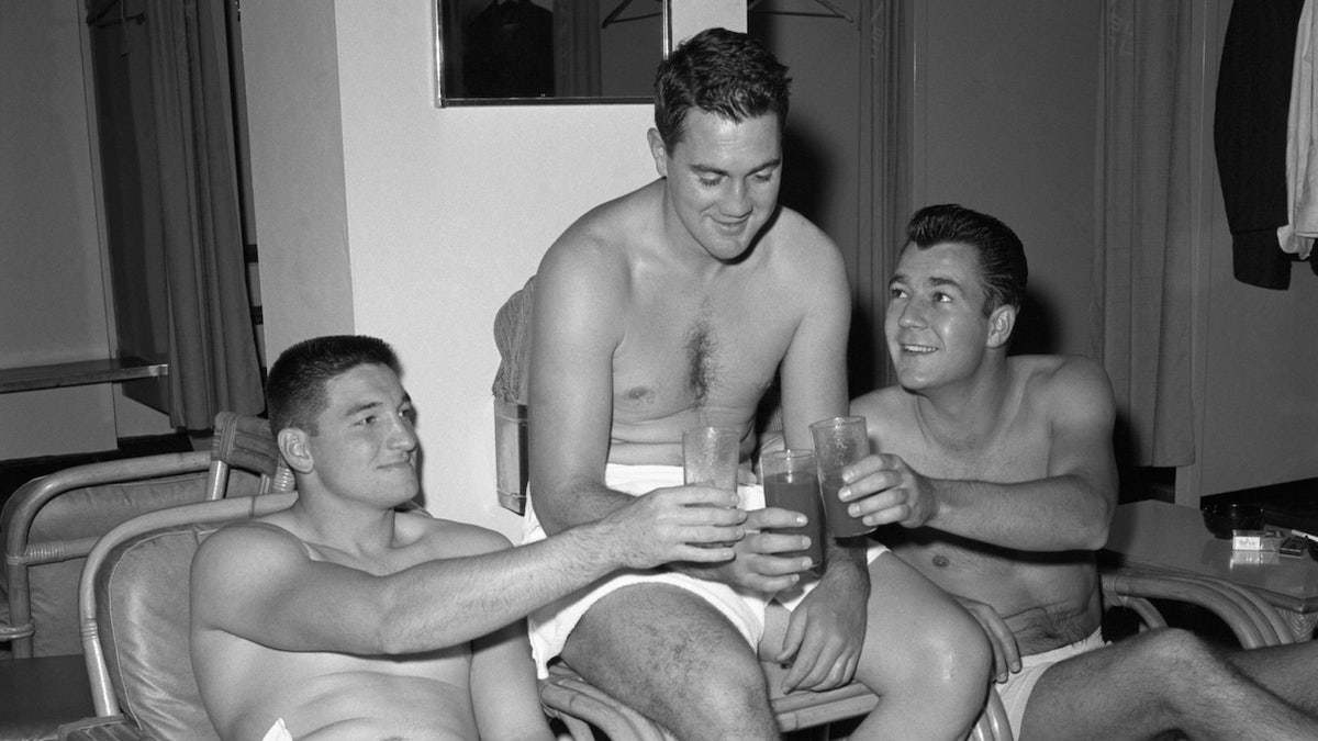 Halfback Phil King (left), star place kicker Pat Summerall (center) and quarterback don Heinrich, of the New York Giants, toast each other with drinks at the Lone Star Boat Club here Nov. 2nd to celebrate their team's smashing of the Green Bay Packers Nov. 1st at Yankee stadium, 20-3. Summer Summerall scored eight points on two field goals and two extra-point kicks.