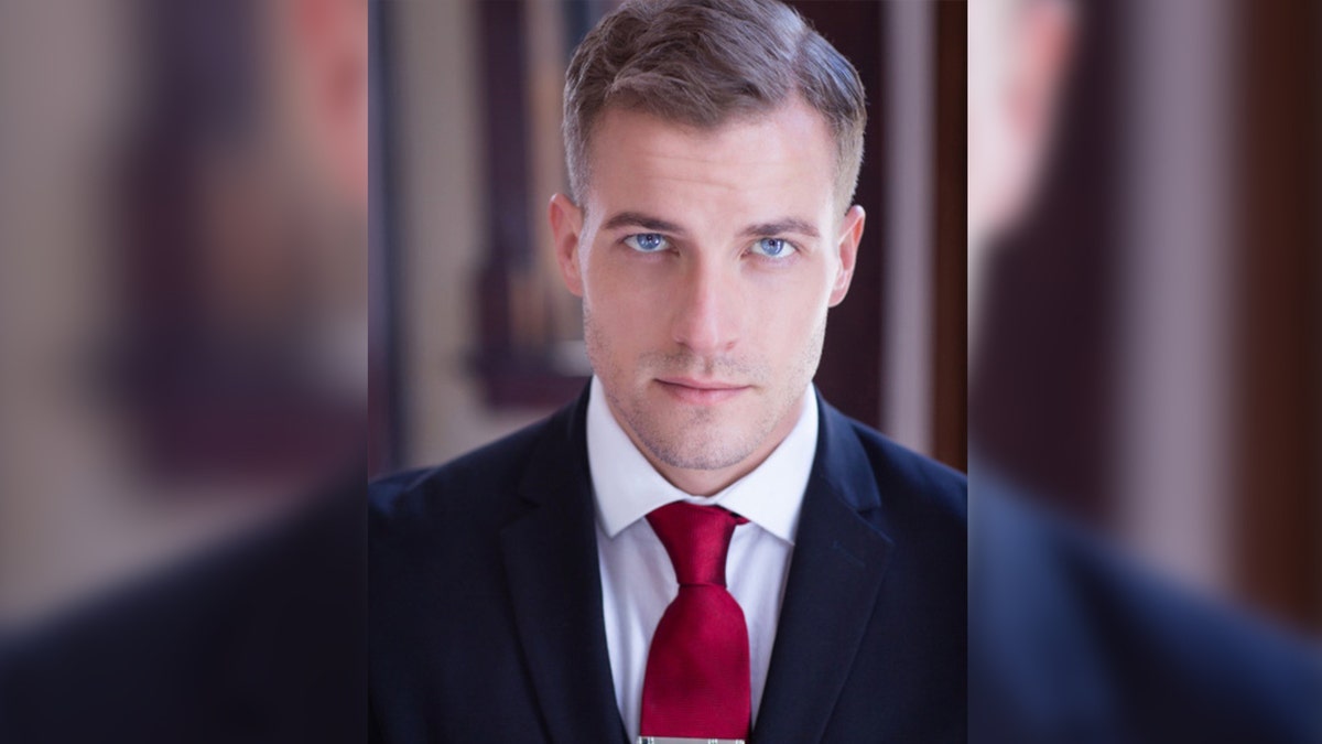 Actor Paul Teal wears a red tie with a dark blazer