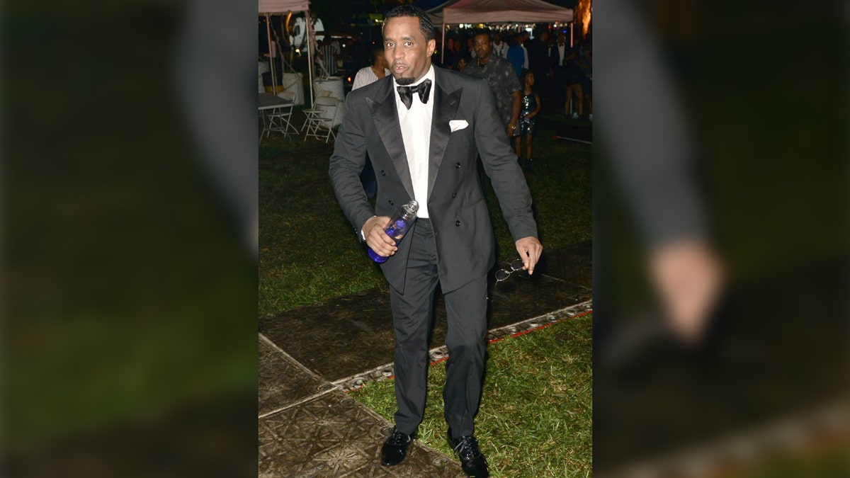 sean diddy combs stubmling in a tuxedo