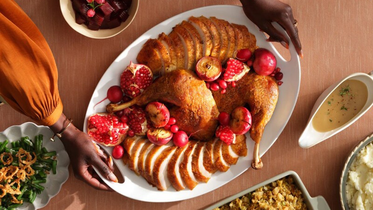 Turkey sliced up next to green bean casserole and other items.