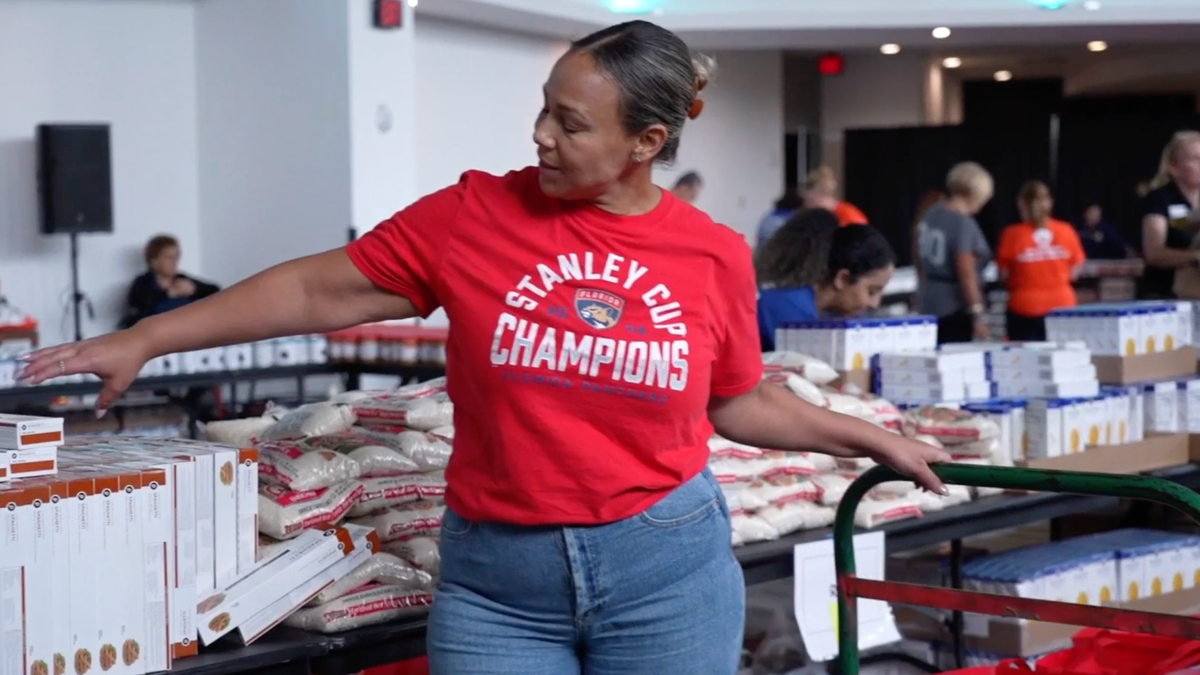 A volunteer wearing a shirt celebrating the Panthers winning the Stanley Cup is seen sorting food collected as part of the 