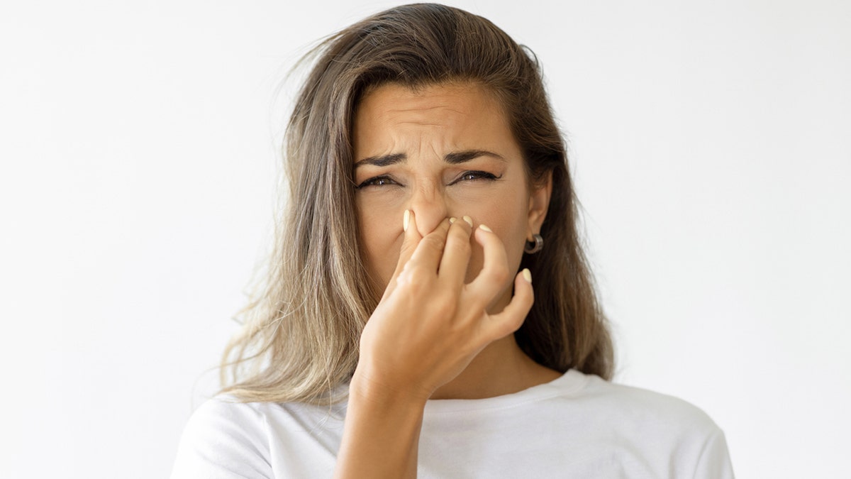 Woman holding her nose