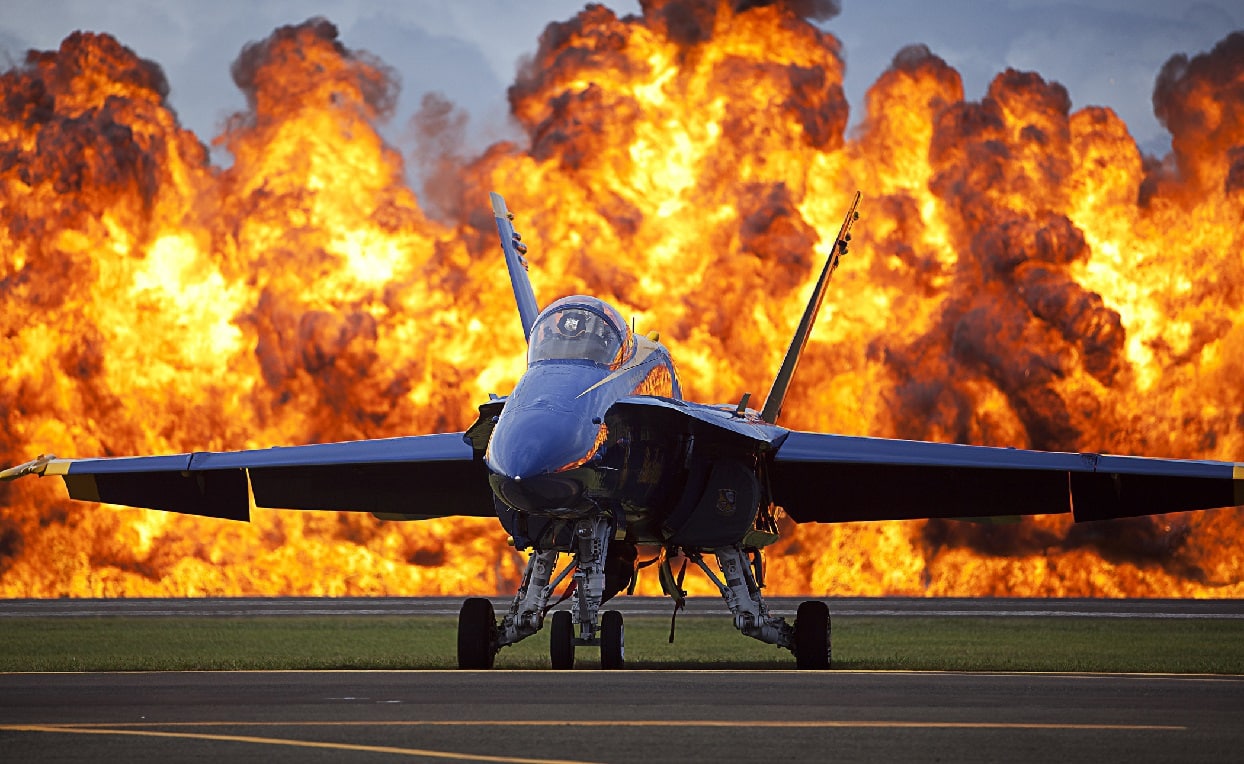 A wall of fire erupts behind a U.S. Navy F/A-18 Hornet aircraft with the Blue Angels, the U.S. Navy flight demonstration squadron, as part of a Marine Air-Ground Task Force demonstration during the 2012 Kaneohe Bay Airshow at Marine Corps Base Hawaii Sept. 28, 2012. (DoD photo by Cpl. Reece Lodder, U.S. Marine Corps/Released)