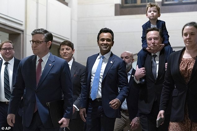 Speaker of the House Mike Johnson, R-La., from left, walks with Vivek Ramaswamy and Elon Musk, who is carrying his son X as they arrive for a roundtable meeting to discuss President-elect Donald Trump's planned Department of Government Efficiency (DOGE), on Capitol Hill in Washington, Thursday, Dec. 5, 2024