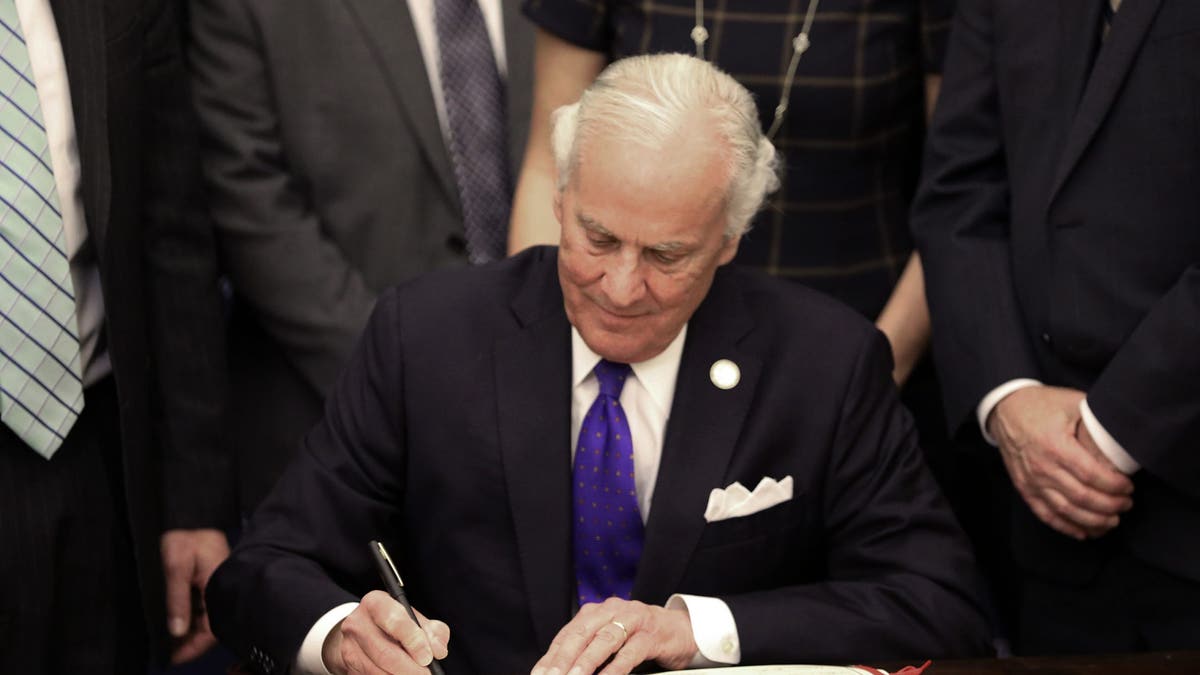 South Carolina Gov. Henry McMaster signs a ceremonial copy of a bill allowing anyone who can legally own a gun to openly carry the weapon in the state at an event on Tuesday, March 19, 2024, in Columbia, S.C.