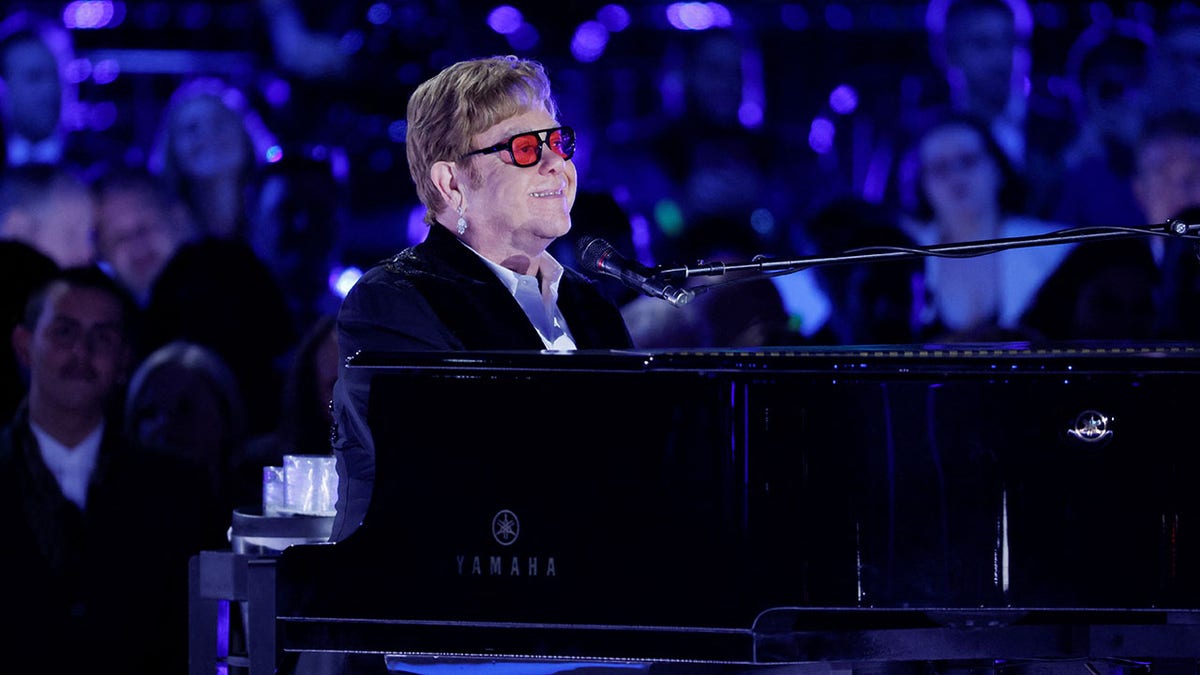 Elton John sitting at his piano