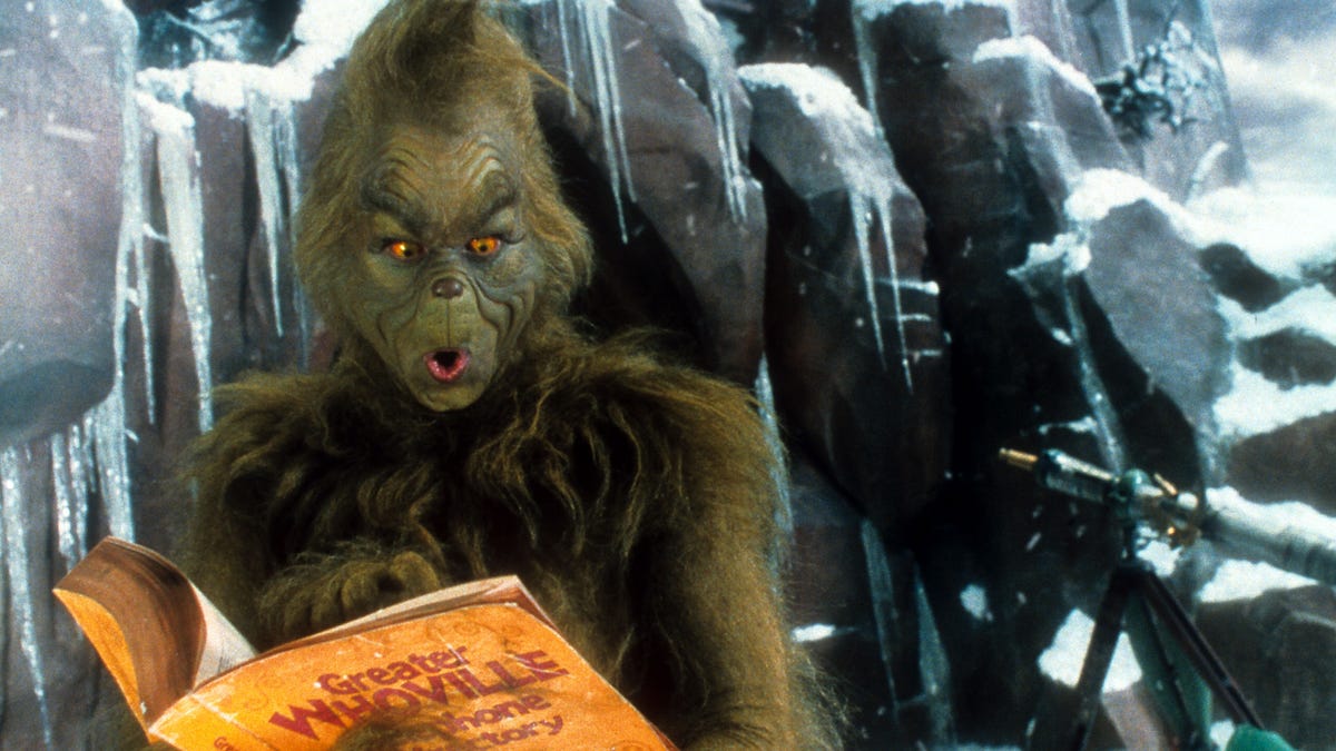 Jim Carrey In 'How The Grinch Stole Christmas' looking curiously to his left while reading something