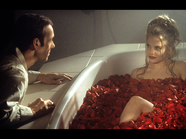 Kevin Spacey looks at Mena Suvari as she bathes in rose pedals in a scene from the film &#