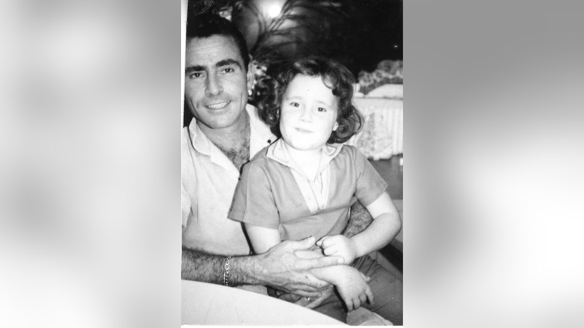 Rod Serling holding a baby Anne Serling on his lap.