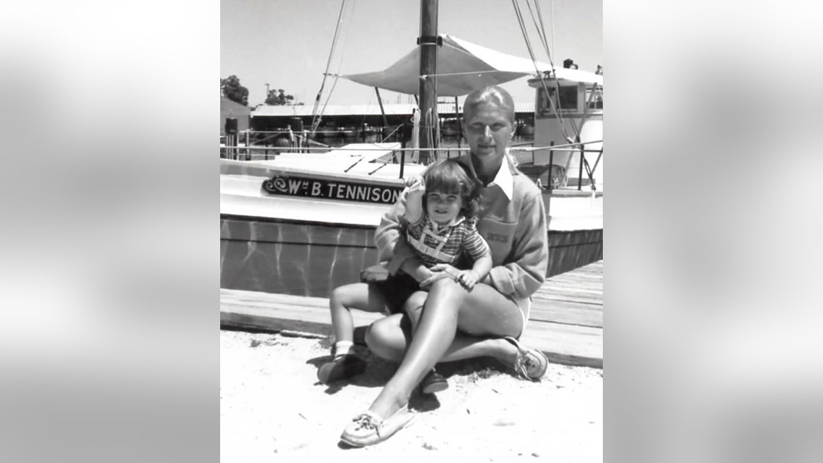 A black and white photo of Noreen Boyle holding her son Collier at the beach.