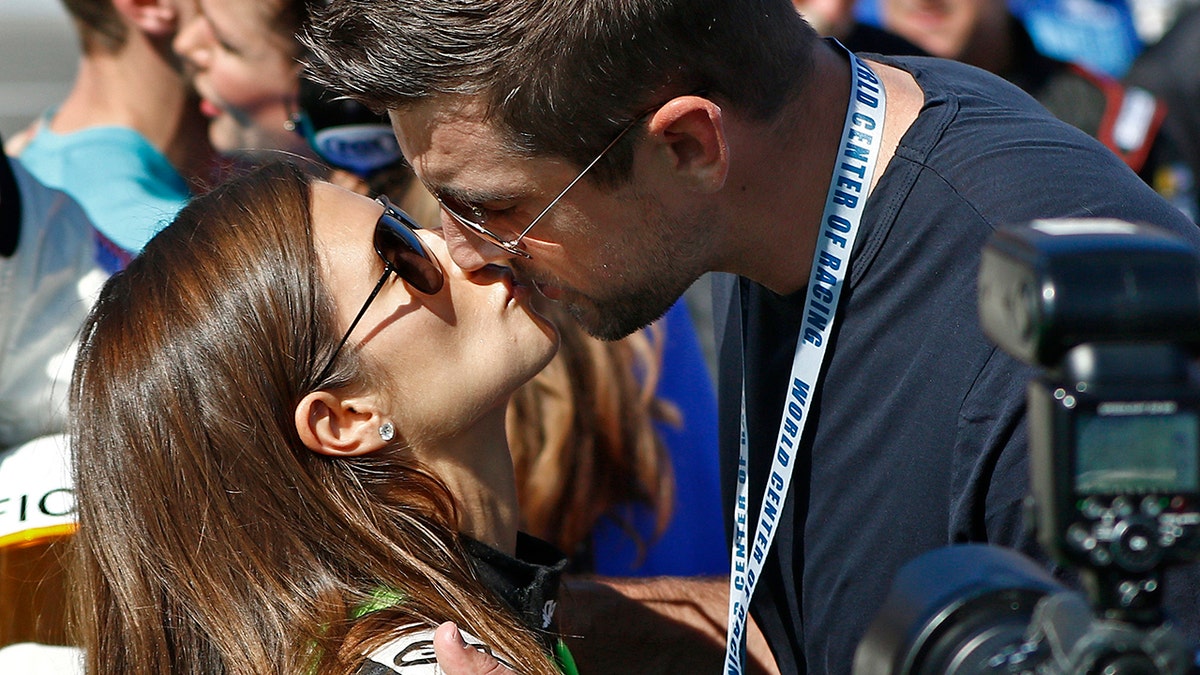 Danica Patrick and Aaron Rodgers share a kiss.